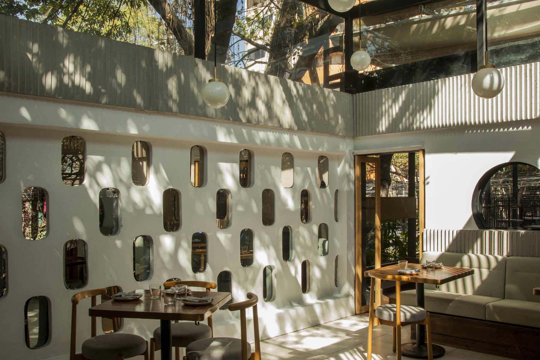 Sunlight across the dining room and decorative wall at Meroma